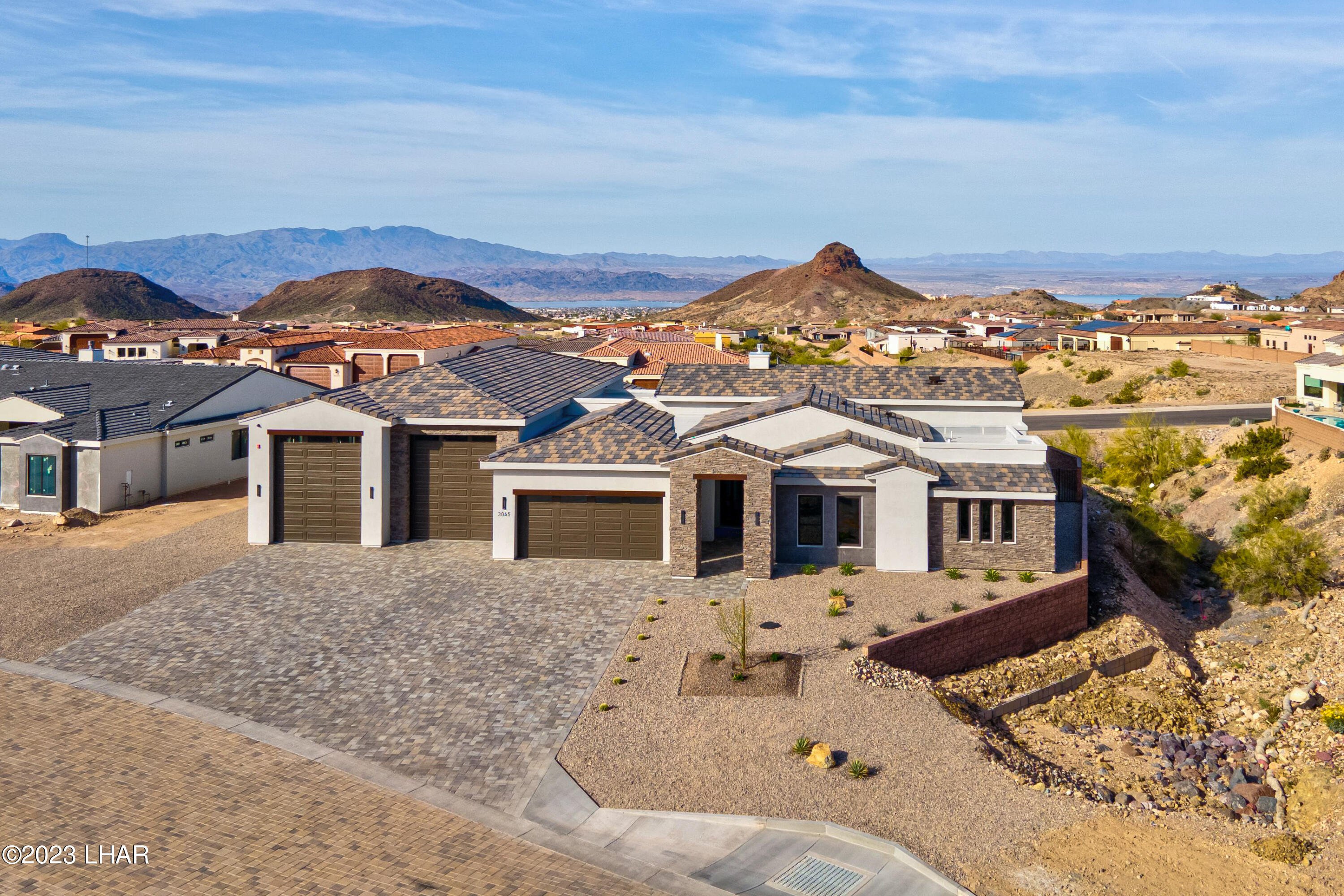 Newer Lake Havasu home with a tall RV garage bay and wide driveway
